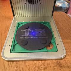 Slate coaster positioned inside the engraving machine during production